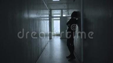 孤独的女人站在沉闷的走廊里<strong>扭动</strong>着